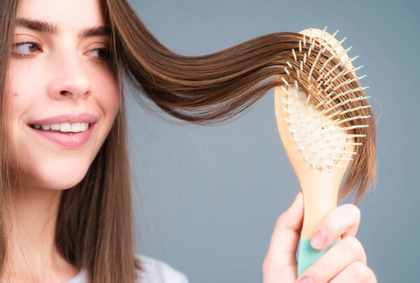 Close up portrait of happy beautiful girl with shiny hair with comb - Foto, afbeelding