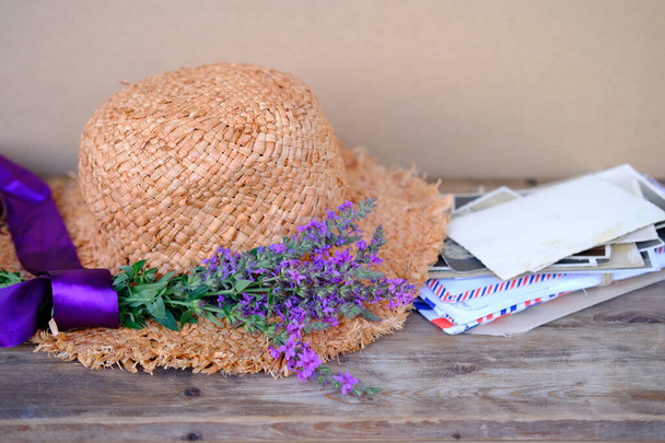 straw hat, old photographs, home archive, letter, bouquet of purple wildflowers on old wooden table, nostalgia, past love, bunch of wild flowers, concept of genealogy, memory of ancestors, family tree - Fotografie, Obrázek