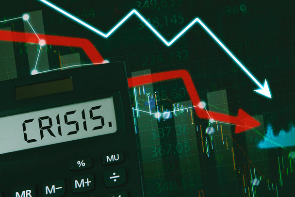Global economic recession, stock market crash - The word crisis on a calculator with bearish market charts - Photo, Image