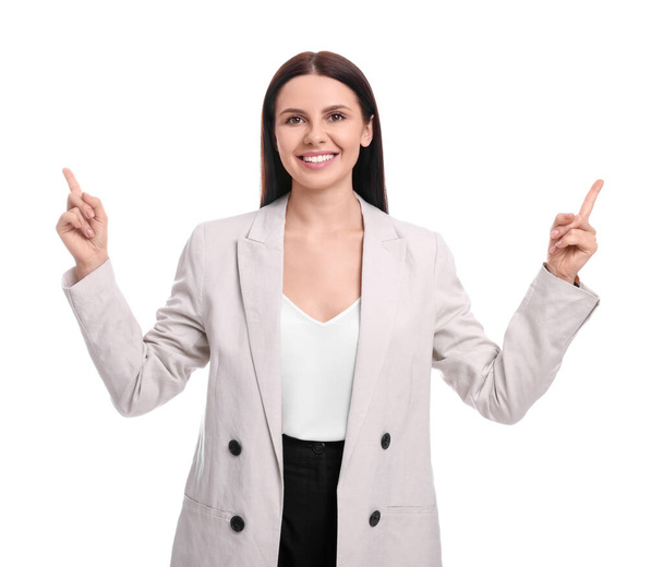 Beautiful businesswoman in suit pointing at something on white background - Foto, imagen