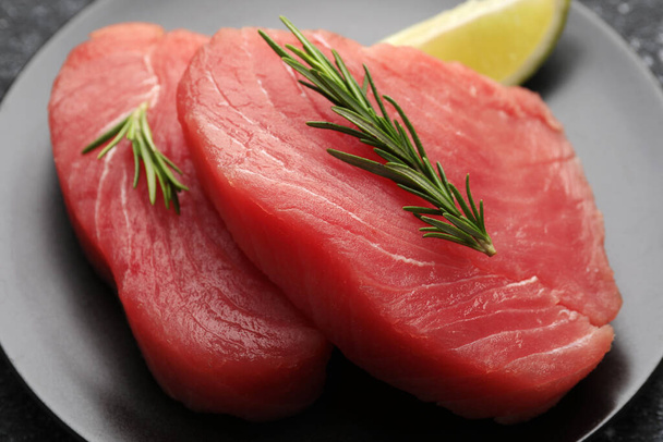 Raw tuna fillets with rosemary on plate, closeup - Photo, Image
