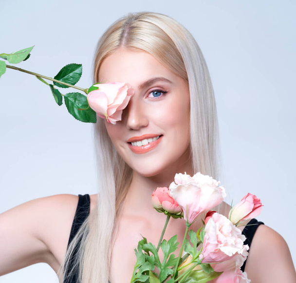 Closeup young personable woman with natural makeup and healthy soft skin holding rose for beauty care advertising in isolated background. Beautiful pretty model girl with flower concept. - Fotoğraf, Görsel