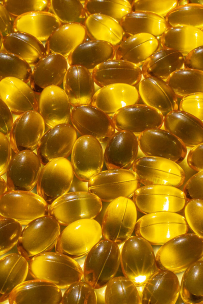 Omega capsules in sunlight. Sunlight reflects fish oil in capsules. The right diet - Φωτογραφία, εικόνα
