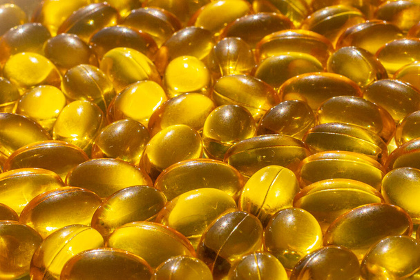 Omega capsules in sunlight. Sunlight reflects fish oil in capsules. The right diet - Photo, Image