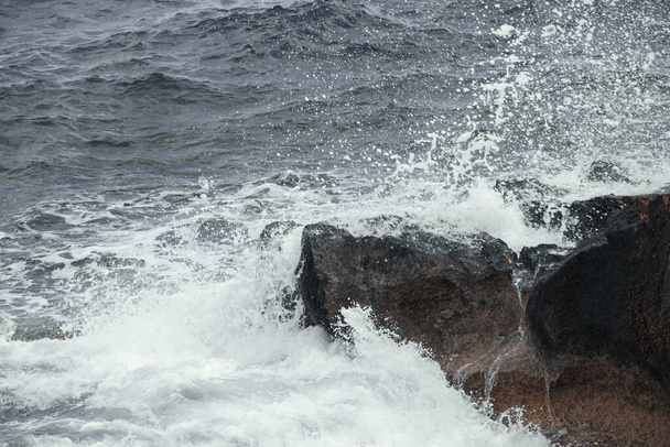 Vue sur la mer, éclaboussures d'eau contre la pierre. - Photo, image