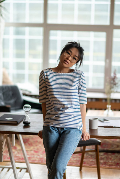 At home. Young asian woman in striped shirt at home - Foto, imagen