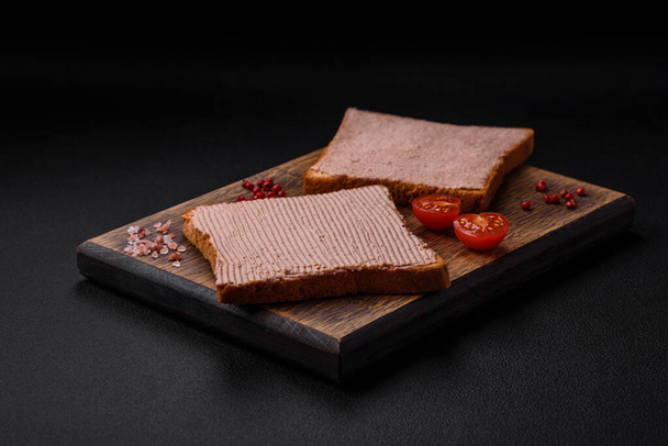 Смачний хрусткий тост з куркою або гусячим паштетом з сіллю та спеціями на темному бетонному фоні
 - Фото, зображення