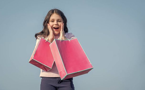 amazed teen kid with shopping paper bag. copy space. - Photo, Image