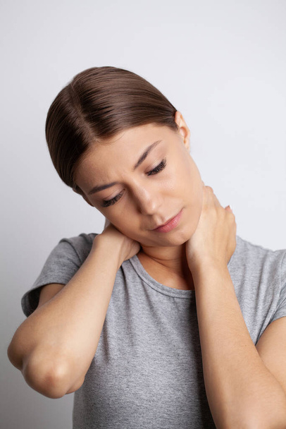 Giovane donna che si sente esausta e soffre di dolore al collo, concetto di salute
 - Foto, immagini
