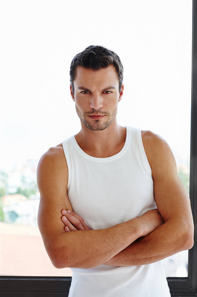 Confident and casual. A handsome man standing with his arms folded in front of his window - Foto, Imagen