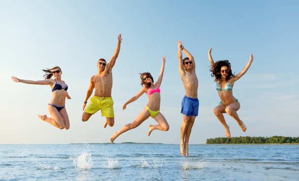 amigos sonrientes en gafas de sol en la playa de verano
 - Foto, imagen
