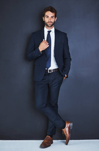 Portrait, fashion and a formal business man in studio on a blue background for contemporary corporate style. Success, professional and a confident young male employee in a suit for executive power. - Foto, afbeelding