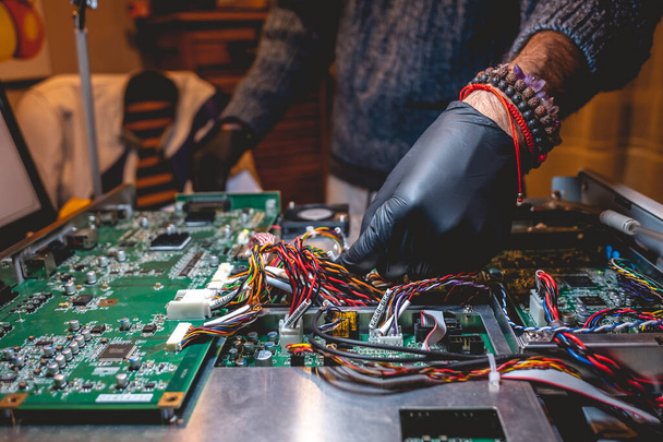 Elektronik uzmanlık: siyah eldivenli ellerin masadaki elektronik ekipmanları tamir etmesi - Fotoğraf, Görsel