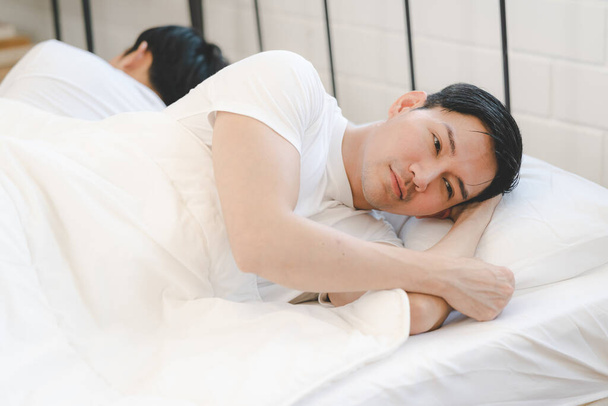 Asian gay couple feeling heartbroken for quarrel conflict and sleep in bedroom. Family problem separation. sad dissatisfied gay couple. Homosexual in problem relationship. - Fotoğraf, Görsel