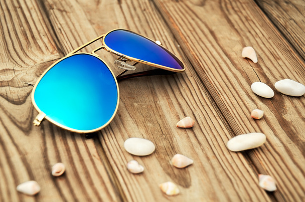 blue mirrored sunglasses and shells on the wooden background clo - Foto, immagini