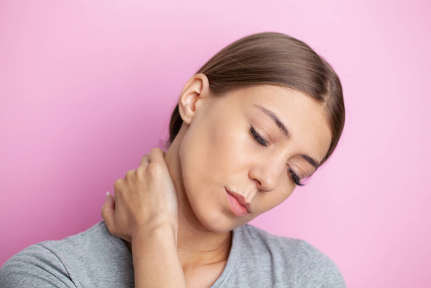 Young woman feeling exhausted and suffering from neck pain, health concept - Foto, imagen