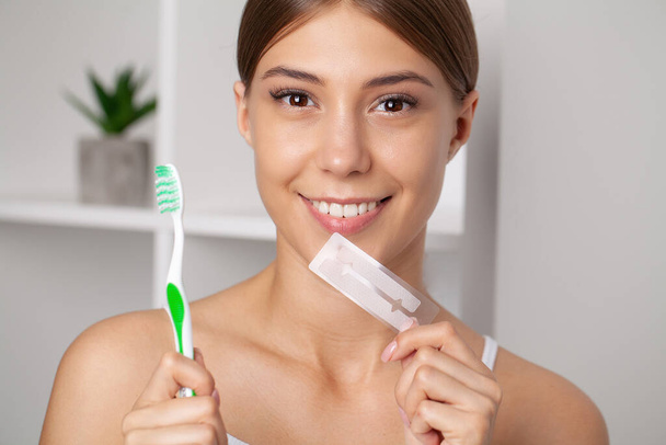Teeth Whitening, Beautiful Smiling Woman Holding Whitening Strip - Foto, imagen