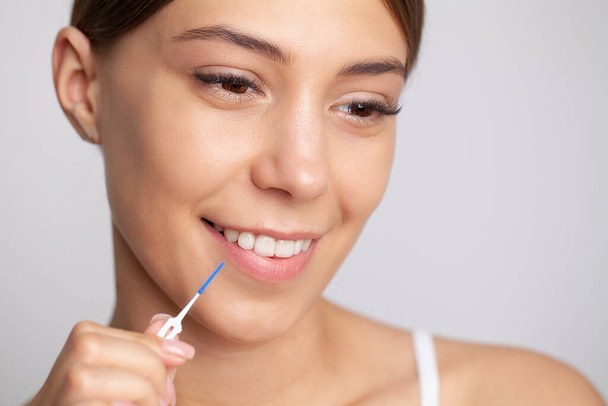 The woman uses brushes to clean the interdental spaces. - Foto, Bild