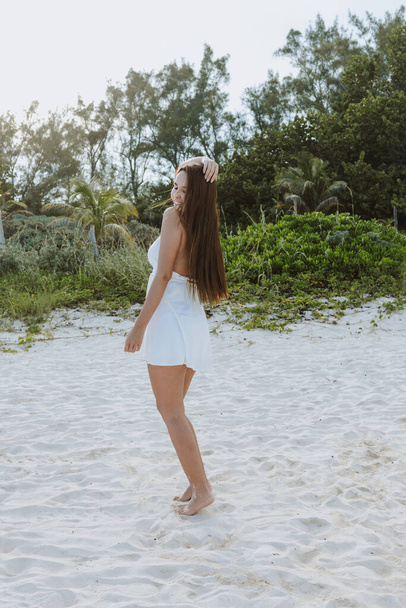portrait of young latin woman wearing white summer dress at the beach in Mexico Latin America, hispanic positive people - Foto, imagen