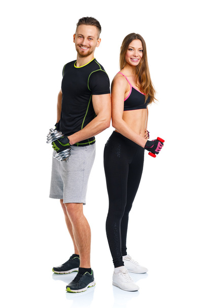 αθλητική ζευγάρι - άνδρας και γυναίκα με αλτήρες στο λευκό - Φωτογραφία, εικόνα