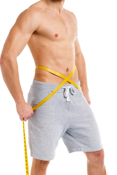 Sport man with measuring tape on the white - Foto, Imagen