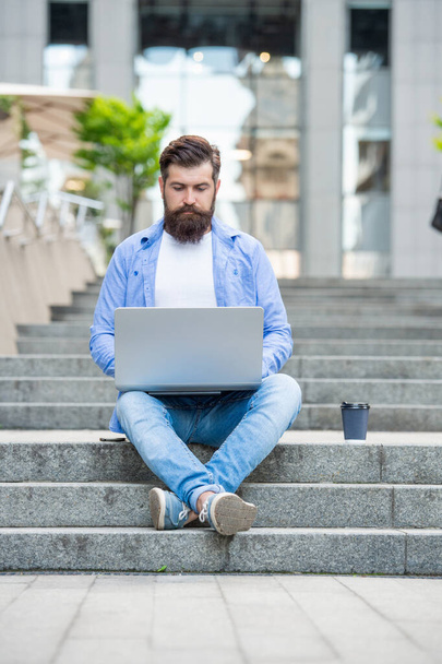 busy man freelancer has video call at coffee break. man freelancer has video call outdoor. man freelancer has video call on laptop. man freelancer has video call outside. - 写真・画像