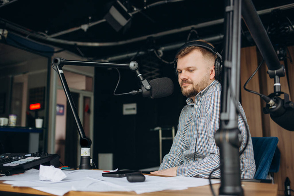 Portrait de présentateur hispanique souriant de radio masculine avec presse-papiers accueillant une émission à la station de radio. - Photo, image
