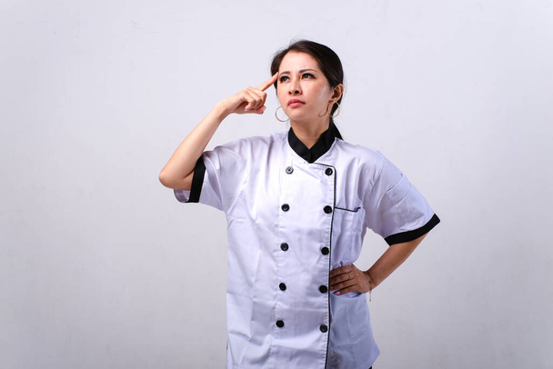 Female Asian chef thinking isolated on white background - Valokuva, kuva