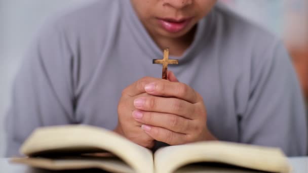 Close-up van een vrouw die een open bijbel leest, bidt en hand in hand haar bijbel vasthoudt. Spirituele of bijbelstudie concept. - Video