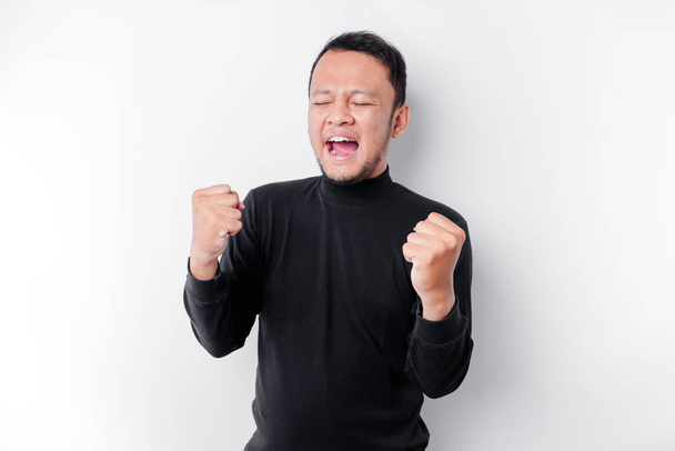 A young Asian man with a happy successful expression wearing black shirt isolated by white background - Fotografie, Obrázek