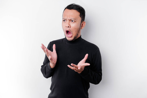 Shocked Asian man with his mouth wide open wearing black shirt, isolated by a white background - Fotografie, Obrázek