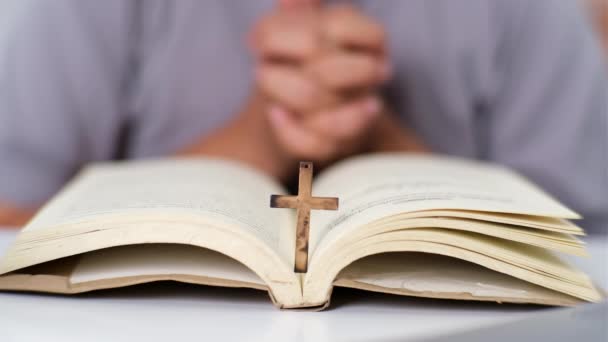 Detailní záběr ženy, jak čte otevřenou bibli, modlí se a drží se za ruce na bibli. Duchovní nebo biblický koncept studia. - Záběry, video