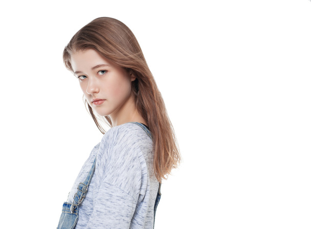 Jeune fille de la mode en jeans salopettes posant isolé
  - Photo, image