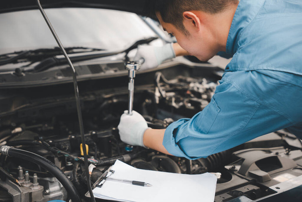 Service outdoor. Asian auto mechanic man working on car engine using wrench to repair and maintenance, broken car care check and fixed the problem and services insurance - Φωτογραφία, εικόνα