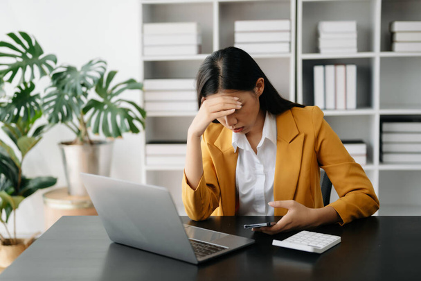 Asian businesswoman is stressed, bored, and overthinking from working  at the office - Foto, afbeelding