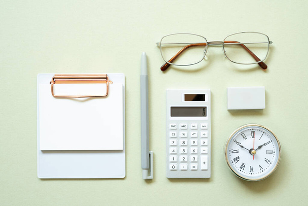 Clipboard, pen, clock, eyeglasses, calculator, eraser on mint desk background. study and workspace. flat lay, top view, copy space - Foto, immagini
