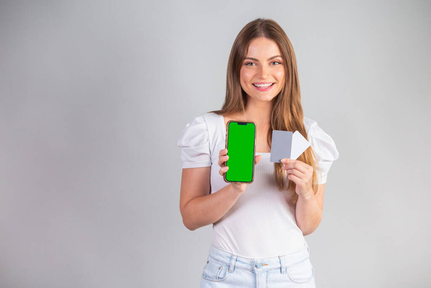 Blonde Brazilian woman showing smartphone and credit cards. - Foto, imagen