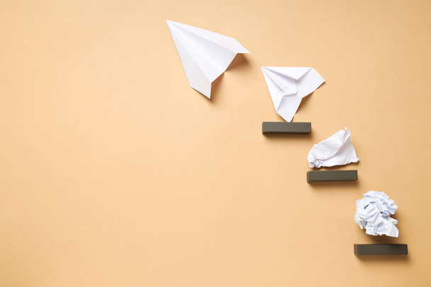 Business, startup and sponsorship concept with paper planes and paper on beige background - Фото, изображение