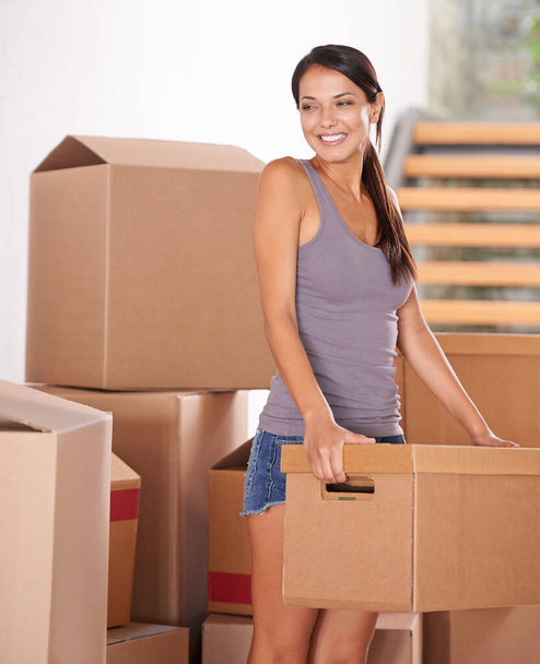 Lächeln Sie, junge Frau, und packen Sie Kartons für neue Hausbesitzer oder Pakete für Logistik und Kundenumzug. Fracht, Fracht und Dame auf dem Grundstück mit einem Paket von einem Kurier oder Versand für Immobilien. - Foto, Bild