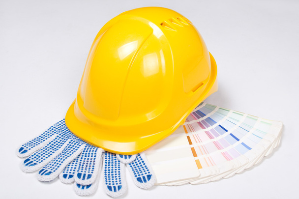 casque jaune, gants de travail et palette colorée au fil blanc - Photo, image