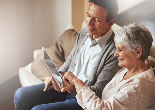 Tablet, relax or old couple streaming film or movies on online subscription in retirement at home together. Love, pointing or senior woman watching videos with a happy elderly man in living room sofa. - Φωτογραφία, εικόνα