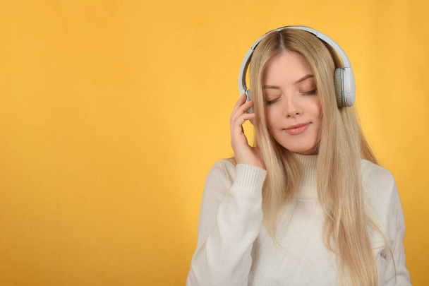 Güzel sarışın kadın kulaklıkla müzik dinlemekten hoşlanıyor. - Fotoğraf, Görsel