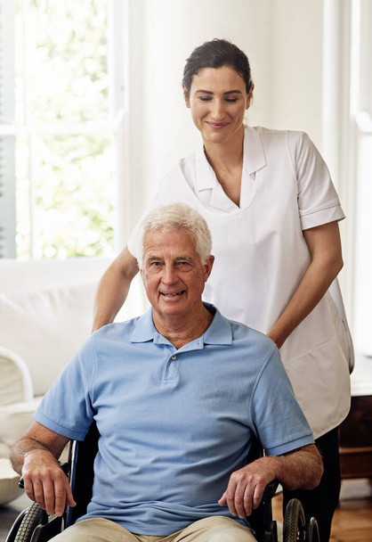 Nurse helping man with disability in wheelchair for medical trust, wellness and support in nursing home. Caregiver, senior patient and therapy service for healthcare, rehabilitation and therapist. - Photo, Image