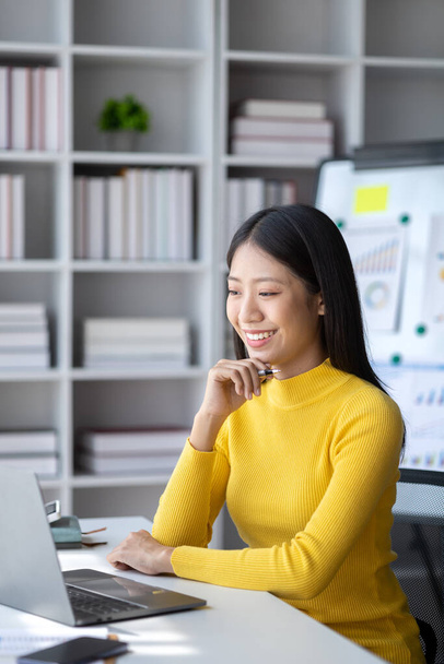 A young woman is a start-up businesswoman, she sits in the office, managing and running a business from a young generation. Startup business management concept. - 写真・画像