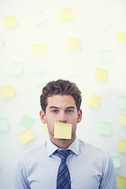 Its all sticky notes and no verbal communication. a young businessman with a sticky note over his mouth - Photo, Image