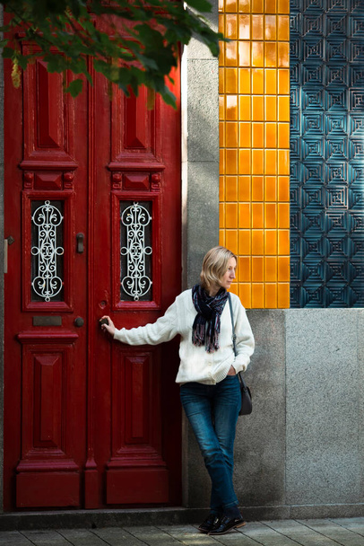 Nainen seisoo odottamassa perinteisen talon ovella. Porto, Portugali. - Valokuva, kuva