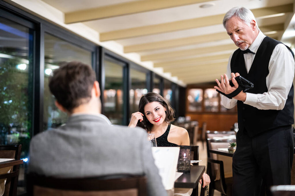 Waiter taking orders in a restaurant - Фото, зображення