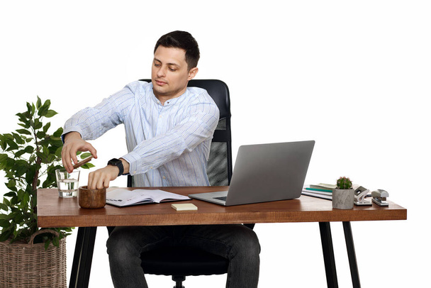 businessman in blue shirt taking notes, using laptop computer on white background - Fotoğraf, Görsel