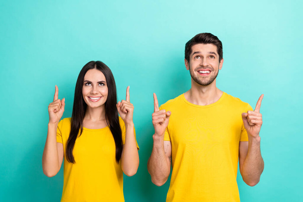 Photo of dreamy cute married couple wear yellow t-shirts looking pointing up empty space isolated teal color background. - Fotoğraf, Görsel
