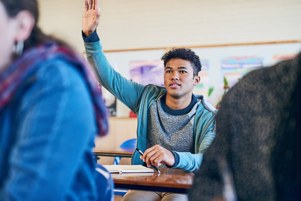 I can answer that. a young man raising his hand in class - Photo, Image